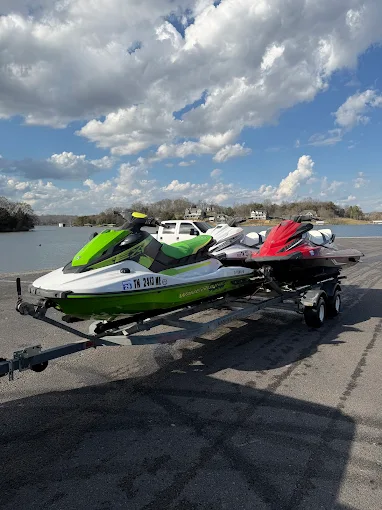 Green and red Yamaha WaveRunner jet ski rentals on trailer at the lake